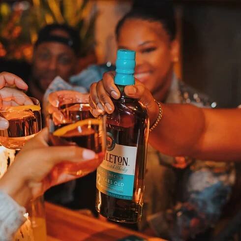 Group toasting with The Singleton of Dufftown 12 Year Old bottle and whiskey glasses