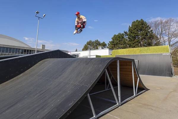 Bruslař ve skoku ve skateparku