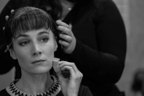 Siobhán Cullen sits, she is having her wig fitted as she does her make up.