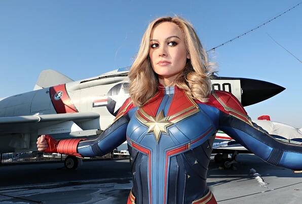 Wax figure of Captain Marvel with a fighter jet behind the figure