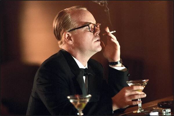 This image may contain Human Person Glass Glasses Accessories Accessory Pub Smoke Smoking Clothing and Overcoat