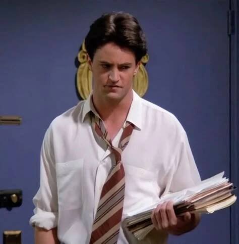 a man wearing a tie holding papers in his hand