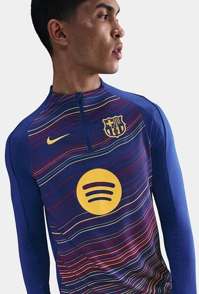 Person wearing a sports jersey with a Spotify logo on a plain background