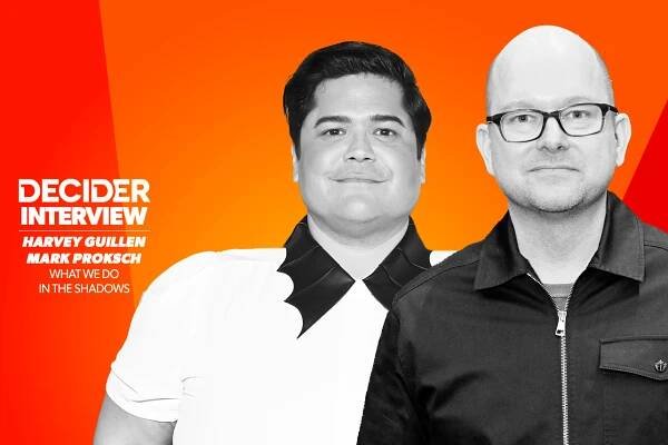Harvey Guillen and Mark Proksch in black and white on a bright orange background