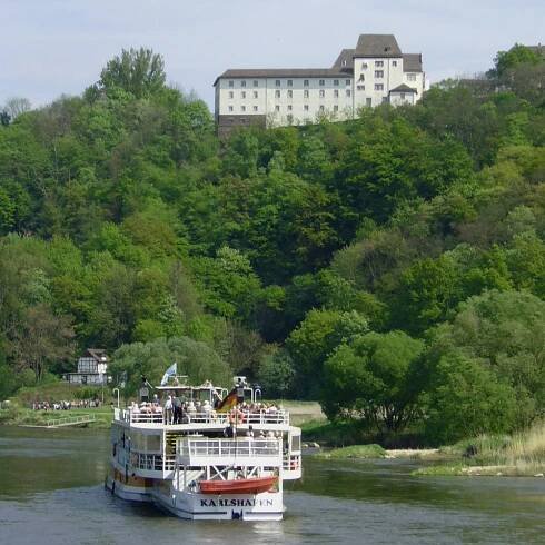 Blick auf der Schloss der Porzellanmanufaktur FÜRSTENBERG von der Weser, im Vordergrund ein Ausflugsschiff auf der Weser