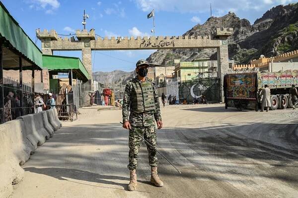 A man in a military uniform standing at a border crossing.
