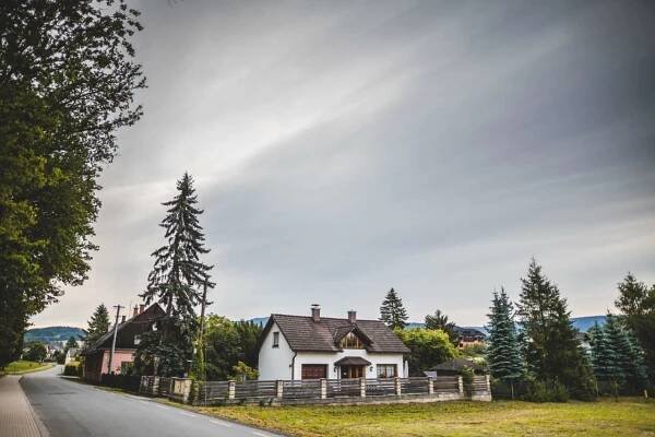 a white house on the side of a road at Penzion u lázní in Velké Losiny