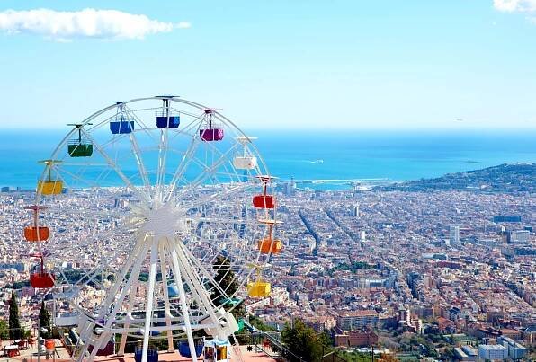 The ferris wheel on Mount Tibidabo in Barcelona, Spain with the sea and city in the background - plus ideas for things to do in Barcelona with kids