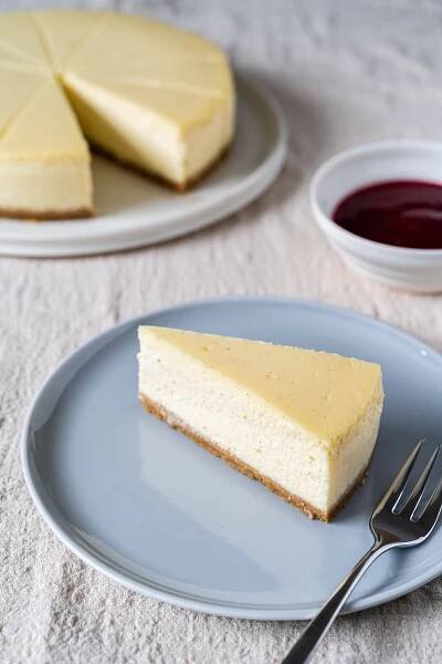Stück cremiger New York Cheesecake auf kleinem Teller