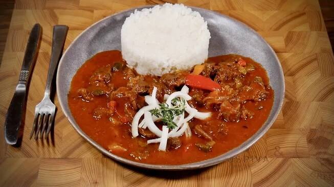 a silver plate topped with meat and rice