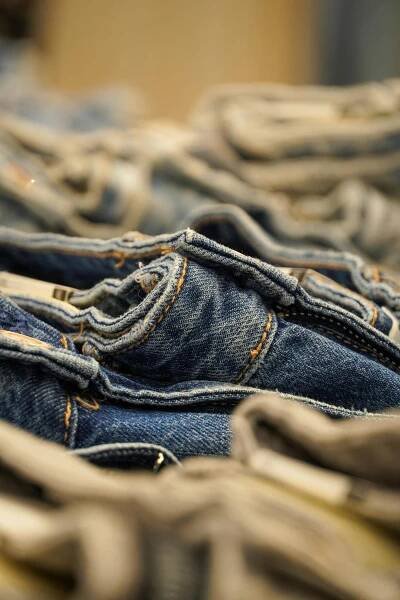 Free A detailed close-up view of neatly folded denim jeans stacked together, showing texture and stitching. Stock Photo