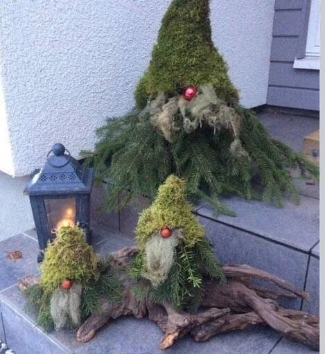 three gnomes made out of branches and pine cones sitting on top of a step