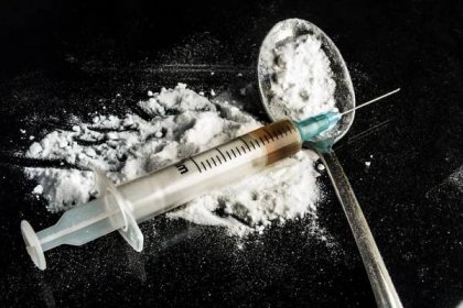 Drogová stříkačka a vařený heroin na lžičce — Stock obrázek
