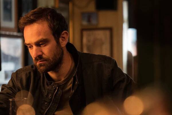 Charlie Cox as Michael Kinsella looking pensive sitting inside in "Kin."
