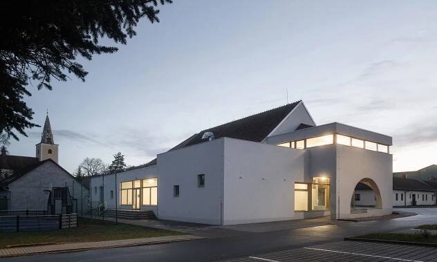 Veverské Knínice opravily a citlivě rozšířily sokolovnu o loubí s oblouky a terasu na úrovni kostela – DesignMag.cz