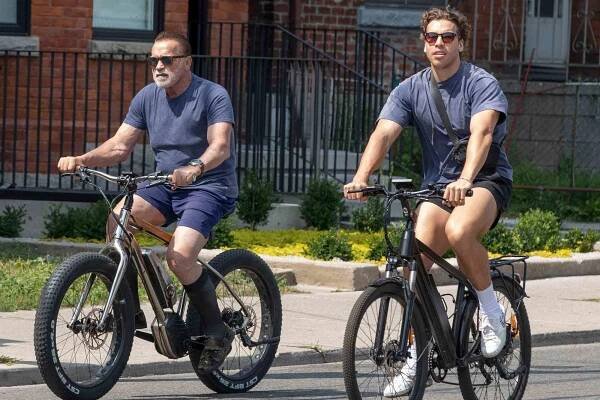 Arnold Schwarzenegger is seen with his son Joseph Baena riding their bikes around Toronto