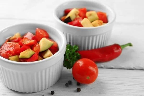 Ratatouille, dušená zeleninová miska s rajčaty, cuketou, lilkem před vařením na dřevěné pozadí — Stock obrázek