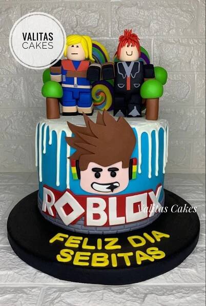 a cake with lego characters on it and the words roblox spelled in spanish