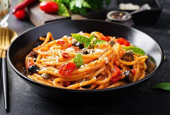 Bowl of spaghetti alla puttanesca with fresh ingredients