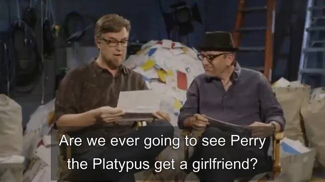 Dan Povenmire and Jeff "Swampy" Marsh sitting next to each other reading a letter that says "Are we ever going to see Perry the Platypus get a girlfriend?"