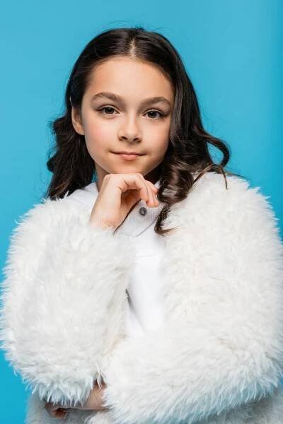 Preteen girl in white faux fur jacket looking at camera isolated on blue,stock image. Preteen model stock images, royalty-free photos and pictures
