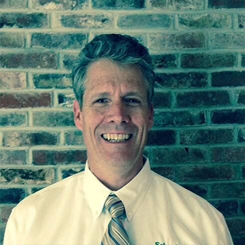 Employee Michael Crowley smiling against a brick wall