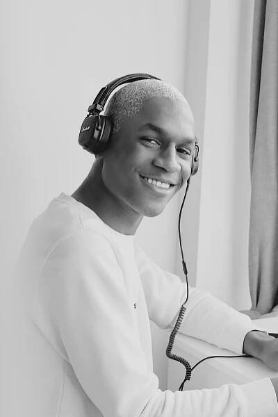 a man with headphones on and smiling at the camera