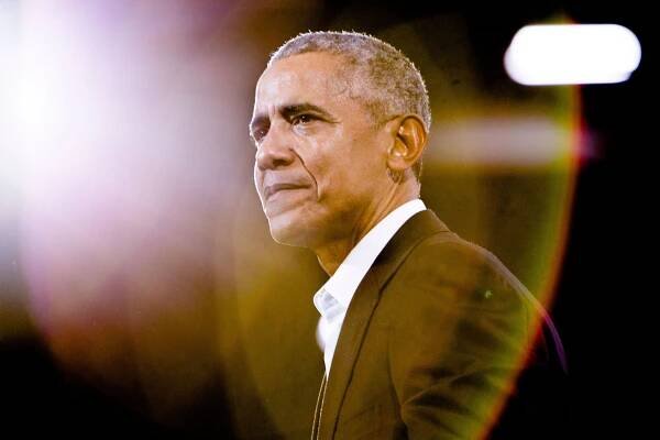 President Barack Obama against a black backdrop with a rainbow lens flare in the upper lefthand corner
