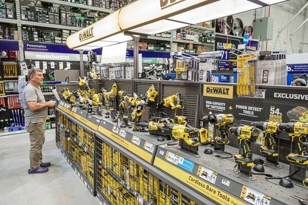 A man shops for DeWalt cordless power tools at a Lowe's.