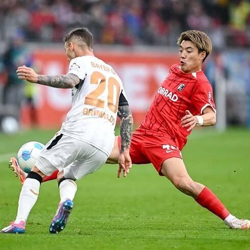 Leverkusens Alejandro Grimaldo und Freiburgs Ritsu Doan kämpfen um den Ball.