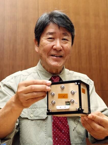 Takao Doi, an astronaut and special professor at Kyoto University, holds the world's first wooden sa...