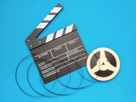 filmová klapka a filmový kotouč na modrém pozadí symbolizujícím filmovou tvorbu a kinematografii - film script - stock snímky, obrázky a fotky