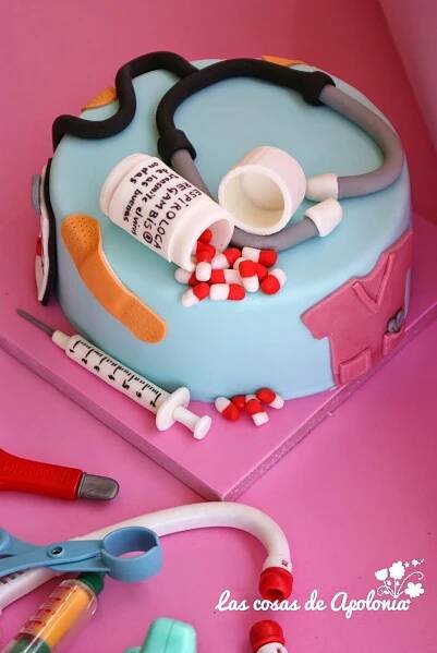 a cake decorated with medical supplies on a pink table