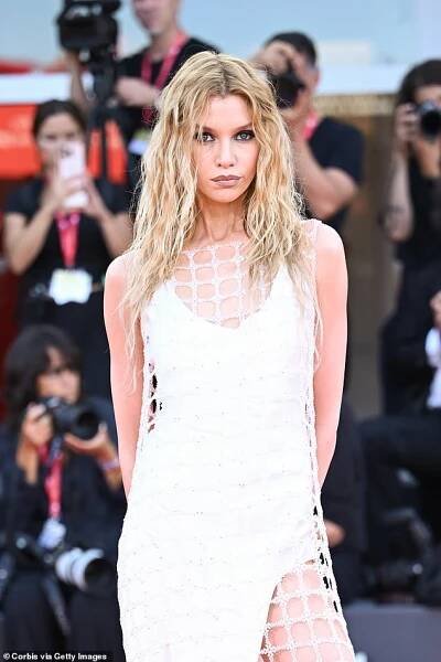 The former Victoria's Secret model, 35, wowed in a white gown with a netted, crochet-like design and a daring thigh-high slit