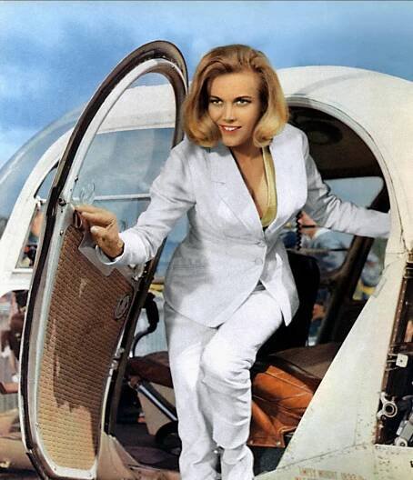 Honor Blackman in a white suit exiting a helicopter in Goldfinger (1964).