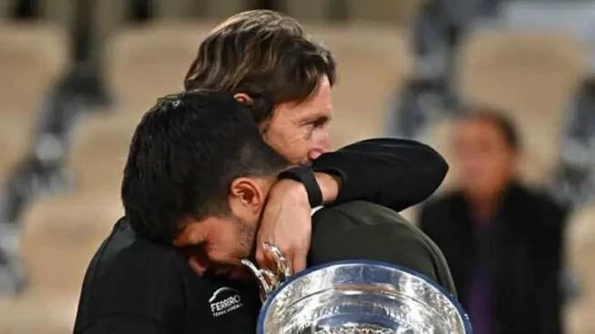 Juan Carlos Ferrero watches a soccer game during Carlos Alcaraz's final