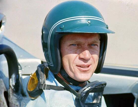 American actor Steve McQueen (1930 - 1980) in Firestone racing driver suit sitting inside a Lola T70 SL70/14 car, at Riverside Raceway in Riverside, California, circa 1966.