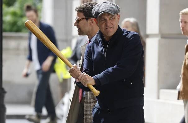 Vinnie Jones holding a baseball bat on a film set.