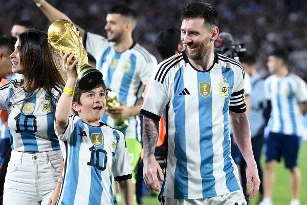 Argentina's forward Lionel Messi (R) looks at his son Thiago as he raises a replica of the World Cup trophy during a recognition ceremony for the World Cup winning team, following the friendly football match between Argentina and Panama at the Monumental stadium in Buenos Aires on March 23, 2023