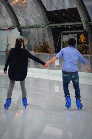 Girl and guy ice skating.