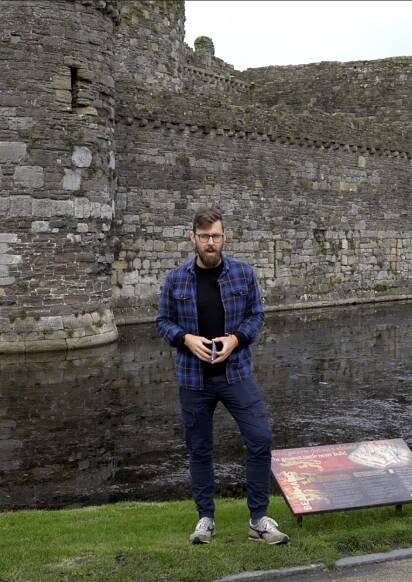 A man standing in front of a castle.