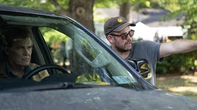 Josh Brolin sits in a truck while Zach Cregger directs him on the set of Weapons