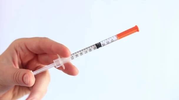 Inzulinová stříkačka. Ženská ruka drží stříkačku na bílém pozadí, zblízka. Inzulinová stříkačka na cukrovku. Léčba cukrovky. Medicína a zdravotní koncepce — Stock záběr