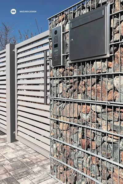 there is a television that is on top of a wall made out of rocks and metal bars