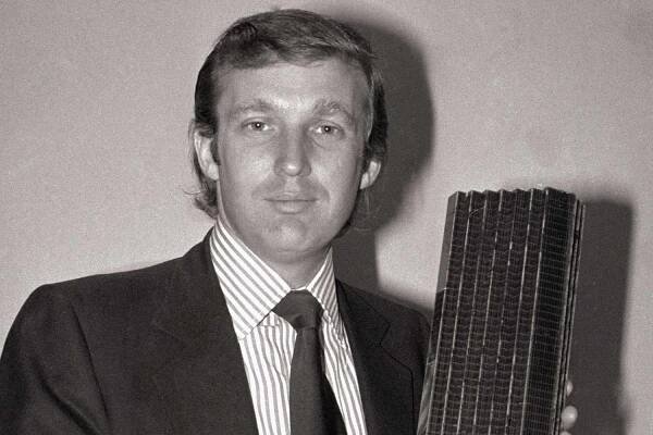 Donald Trump, 33-year-old golden boy of New York real estate, holds a model of the Fifth Avenue tower that will have shops, offices and co-ops