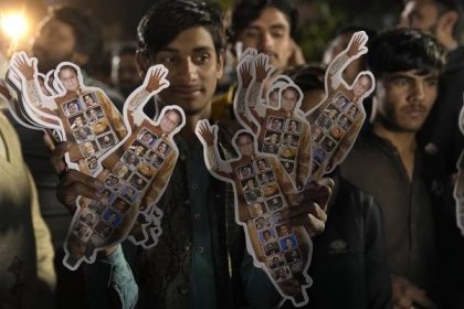 A supporters of Former Prime Minister Nawaz Sharif' party 'Pakistan Muslim League-N' holds the cutouts of his leader as he with other celebrate their party victory in the initial results of the country's parliamentary election, in Lahore, Pakistan, Friday, Feb. 9, 2024. (AP Photo/K.M. Chaudary)