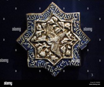 Tile with phoenix and Quranic text. Iran. 1275-1325. Moulded fritware with color i and lustre over glaze. Victoria and Albert Museum. London. England. United Kingdom. Stock Photo