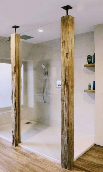 a bathroom with wooden floors and walls, including a walk in shower next to the tub