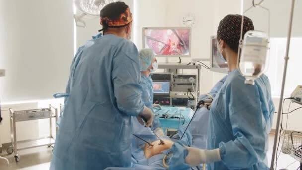 Operace pomocí laparoskopického zařízení. Proces gynekologického chirurgického zákroku za použití laparoskopického vybavení. Skupina chirurgů na operačním sále s chirurgickým vybavením. — Stock záběr