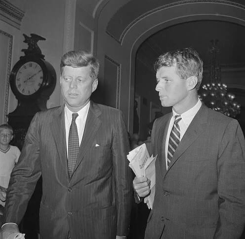 Senator John Kennedy (Mass.)(left), democratic Presidential nominee, confers with his brother Robert while enroute to the Senate floor to vote on the Medical care for the aged bills. 